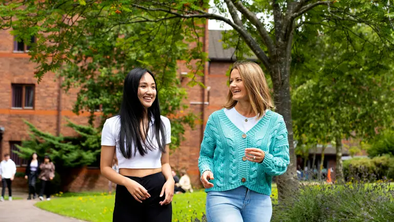 Two students walking in front of Ribble Hall