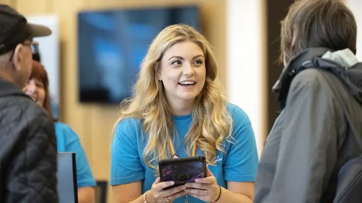 A member of UCLan staff chatting with graduates