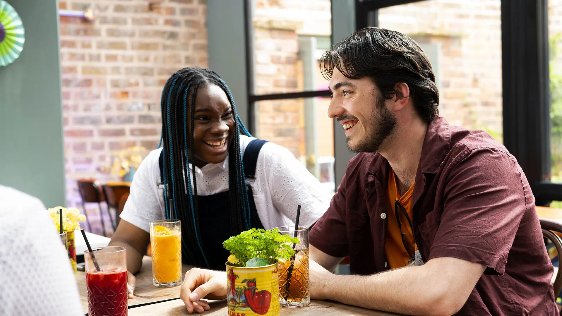 students chatting and drinking juice at a table inside a restaurant