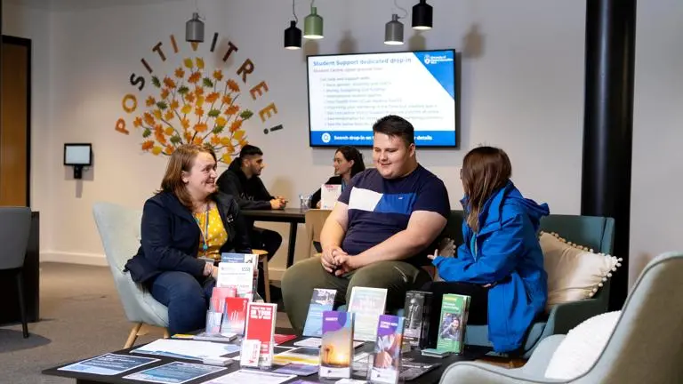 Student with a wellbeing ambassador and staff member in the student support drop in centre