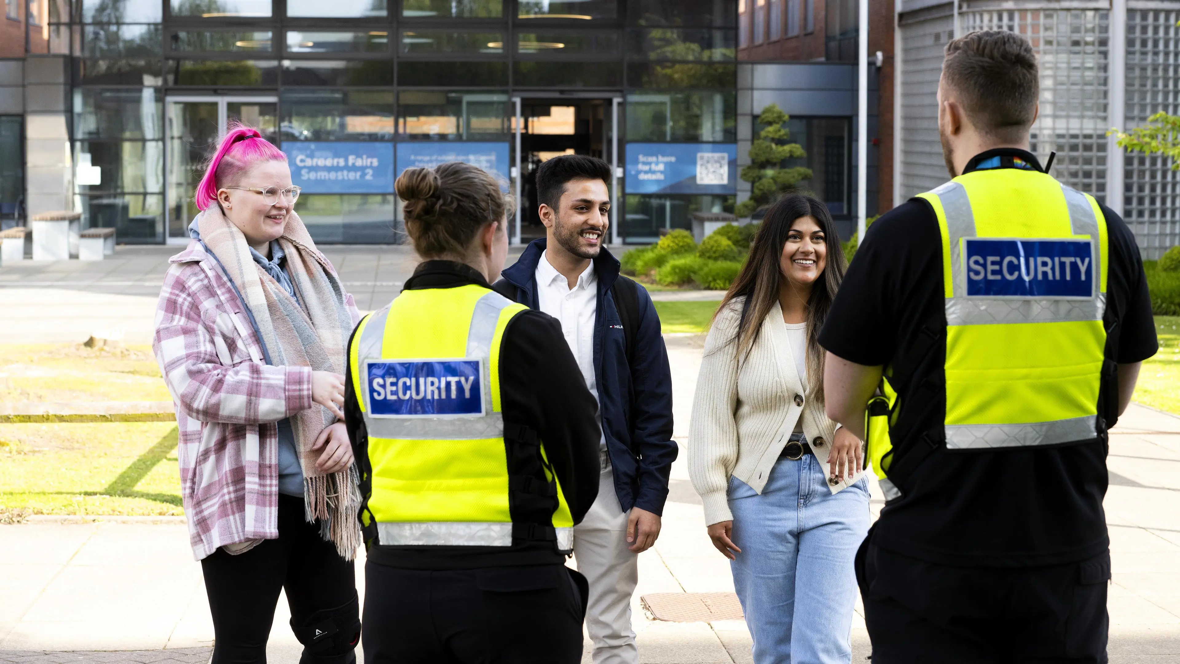 Security Team standing with students outside a campus building