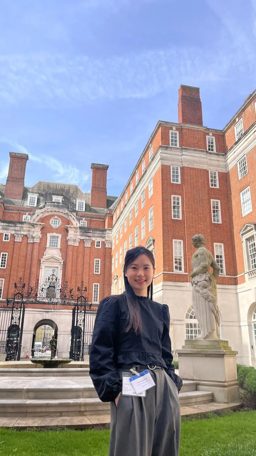 Yan Ching Chow standing in front of a red brick building